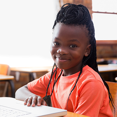 A smiling schoolgirl at her desk